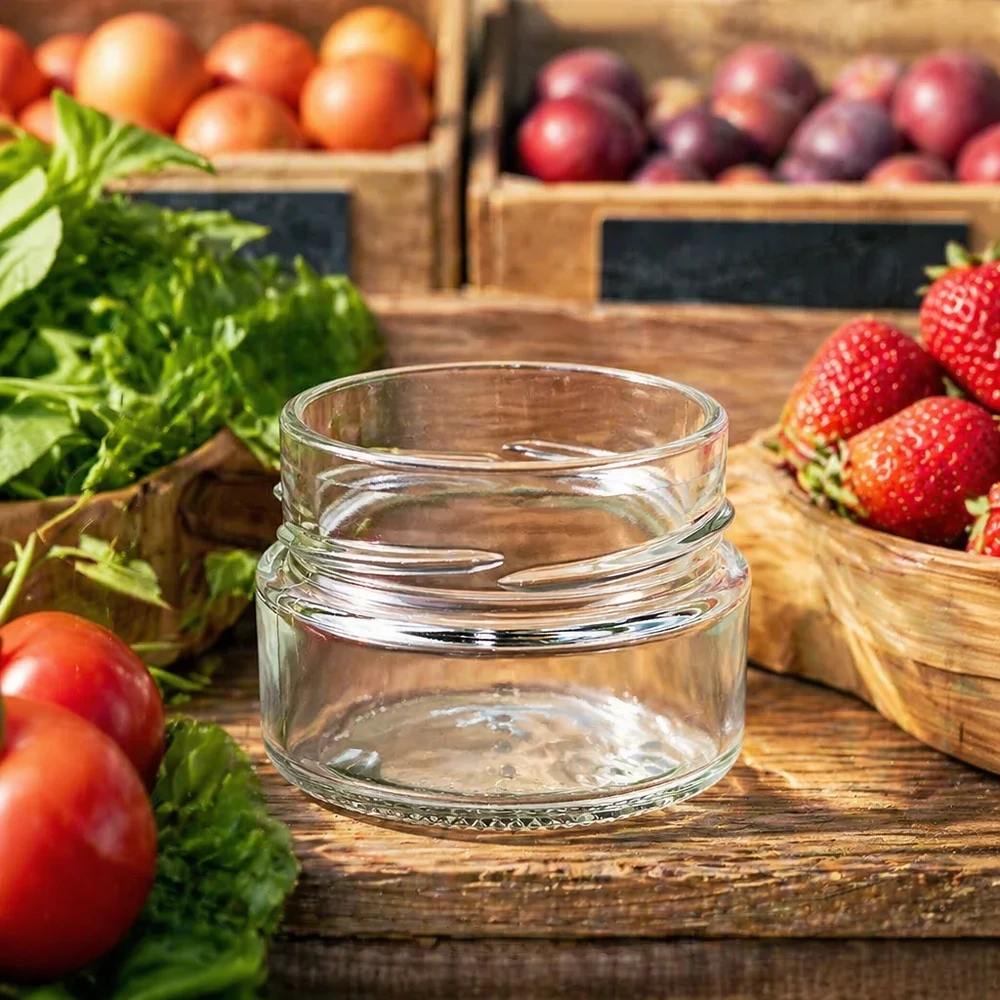 UNiTWIST Runda80 Rundglas 80ml TO58deep leeres Einmachglas auf Holztisch mit frischem Obst und Gemüse im Hintergrund