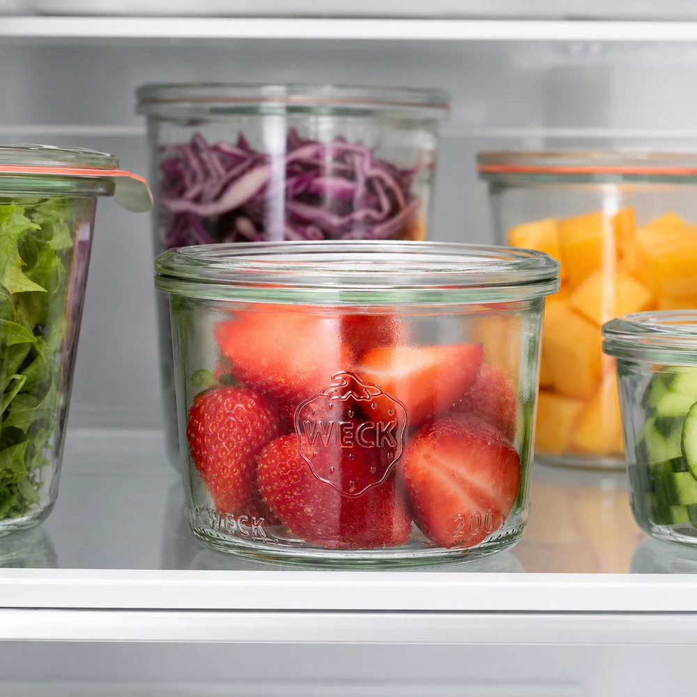 WECK Sturzglas 200ml RR80 mit frischen Erdbeeren im Kühlschrank neben anderen gefüllten Gläsern mit Gemüse und Obst